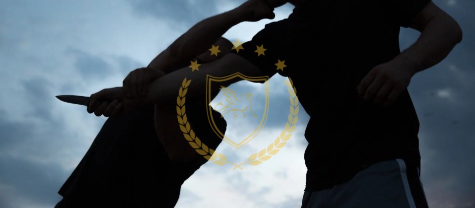Silhouettes of two figures, one holding a knife, against a pale sky.